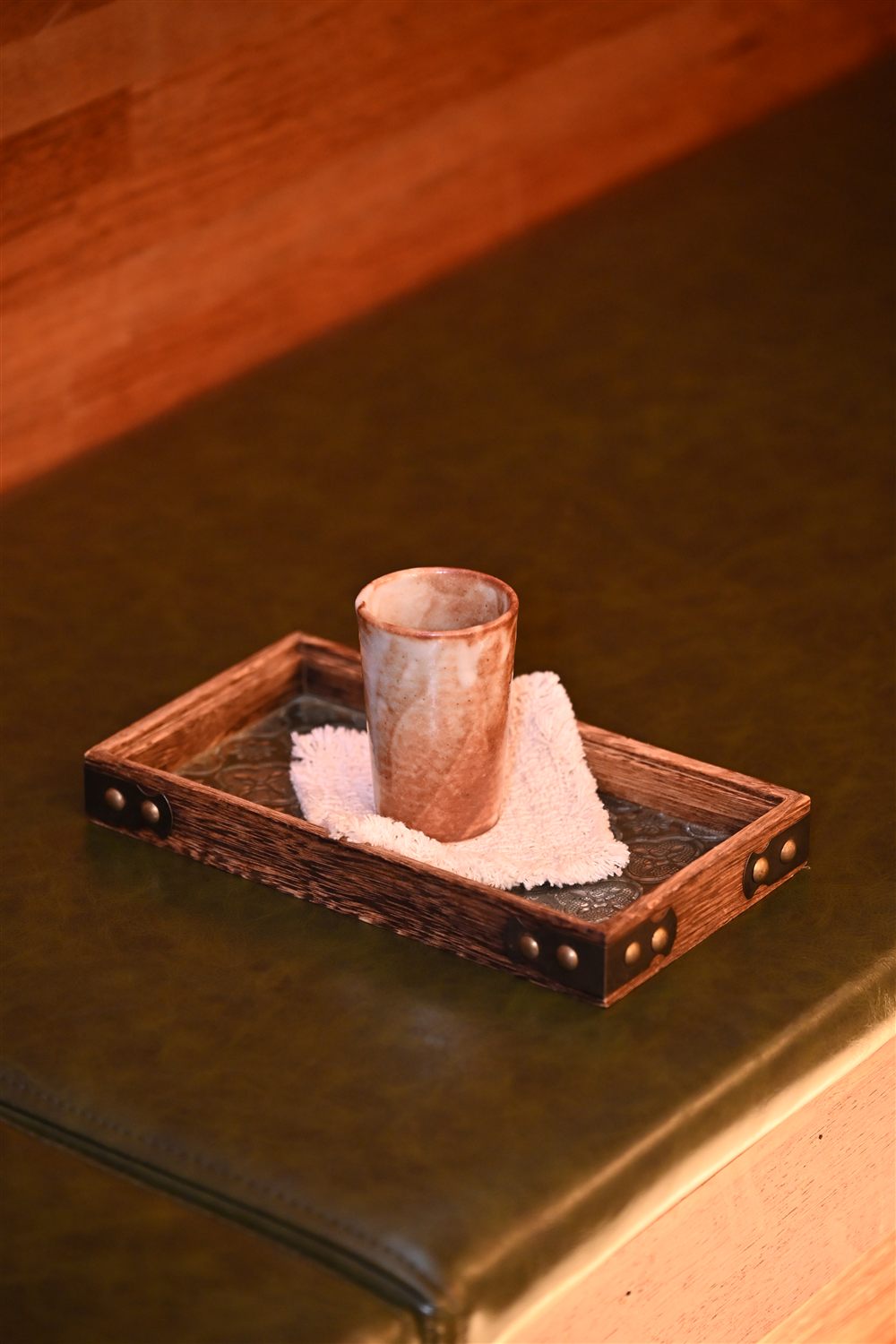 A cup of water on a wooden tray to finish